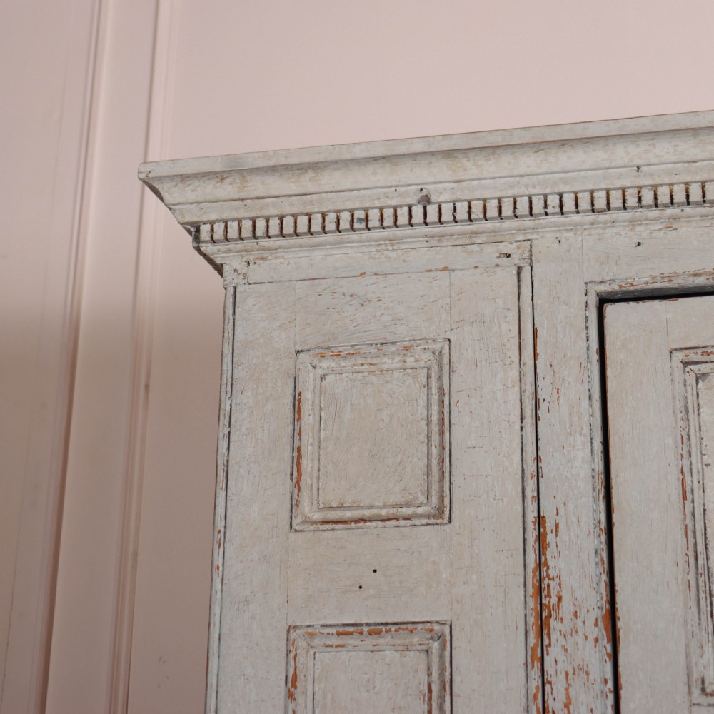 A small antique English housekeepers cupboard with a pale blue painted finish, panelled doors, turned wooden knobs, and bracket feet. View IV
