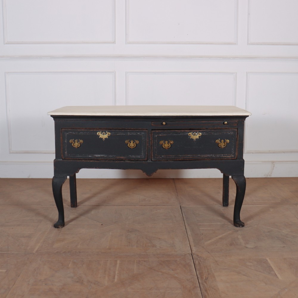 An 18th-century black painted wooden dresser base featuring two drawers with ornate brass handles, a light top, shaped apron, and four cabriole legs.