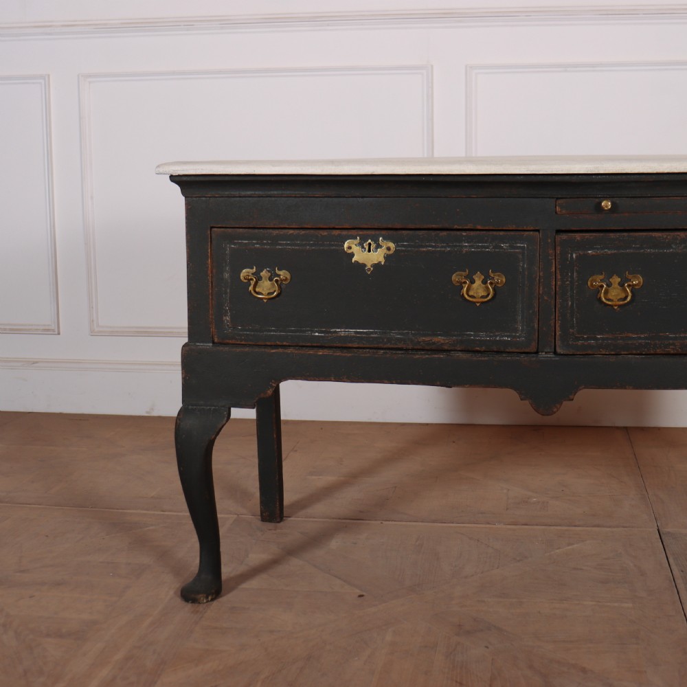 An 18th-century black painted wooden dresser base featuring two drawers with ornate brass handles, a light top, shaped apron, and four cabriole legs. View II