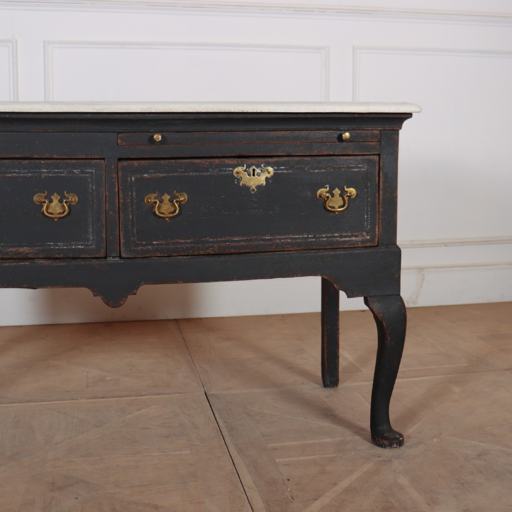 An 18th-century black painted wooden dresser base featuring two drawers with ornate brass handles, a light top, shaped apron, and four cabriole legs. View III