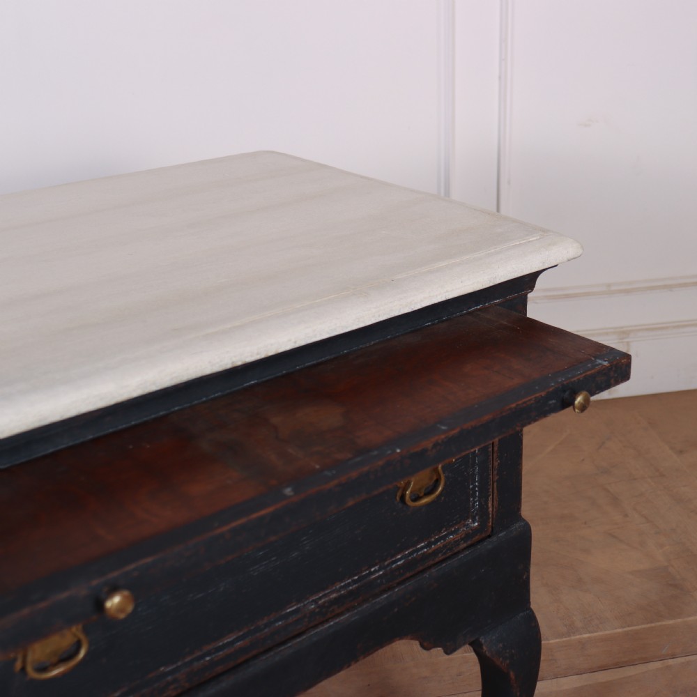An 18th-century black painted wooden dresser base featuring two drawers with ornate brass handles, a light top, shaped apron, and four cabriole legs. View VI