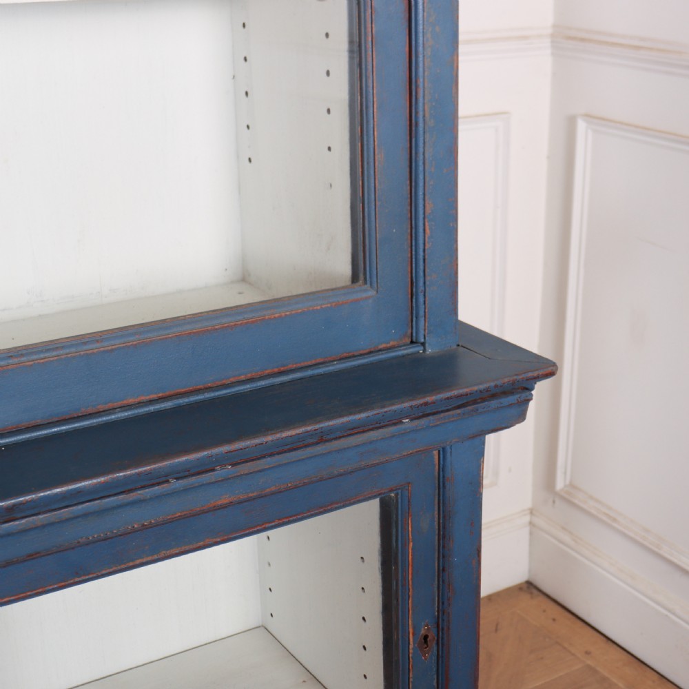 A large two-tier blue painted display cabinet featuring sliding glass doors and a white painted interior fitted with shelves. View IV