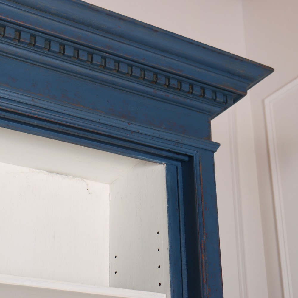 A large two-tier blue painted display cabinet featuring sliding glass doors and a white painted interior fitted with shelves. View IX