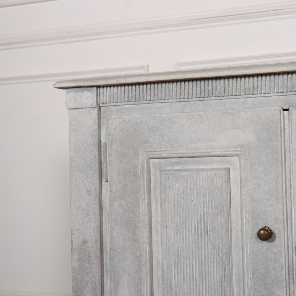 A pair of Swedish enfilades featuring a distressed pale grey painted finish, panelled cupboard doors, small round brass knobs, and short tapered legs. View II
