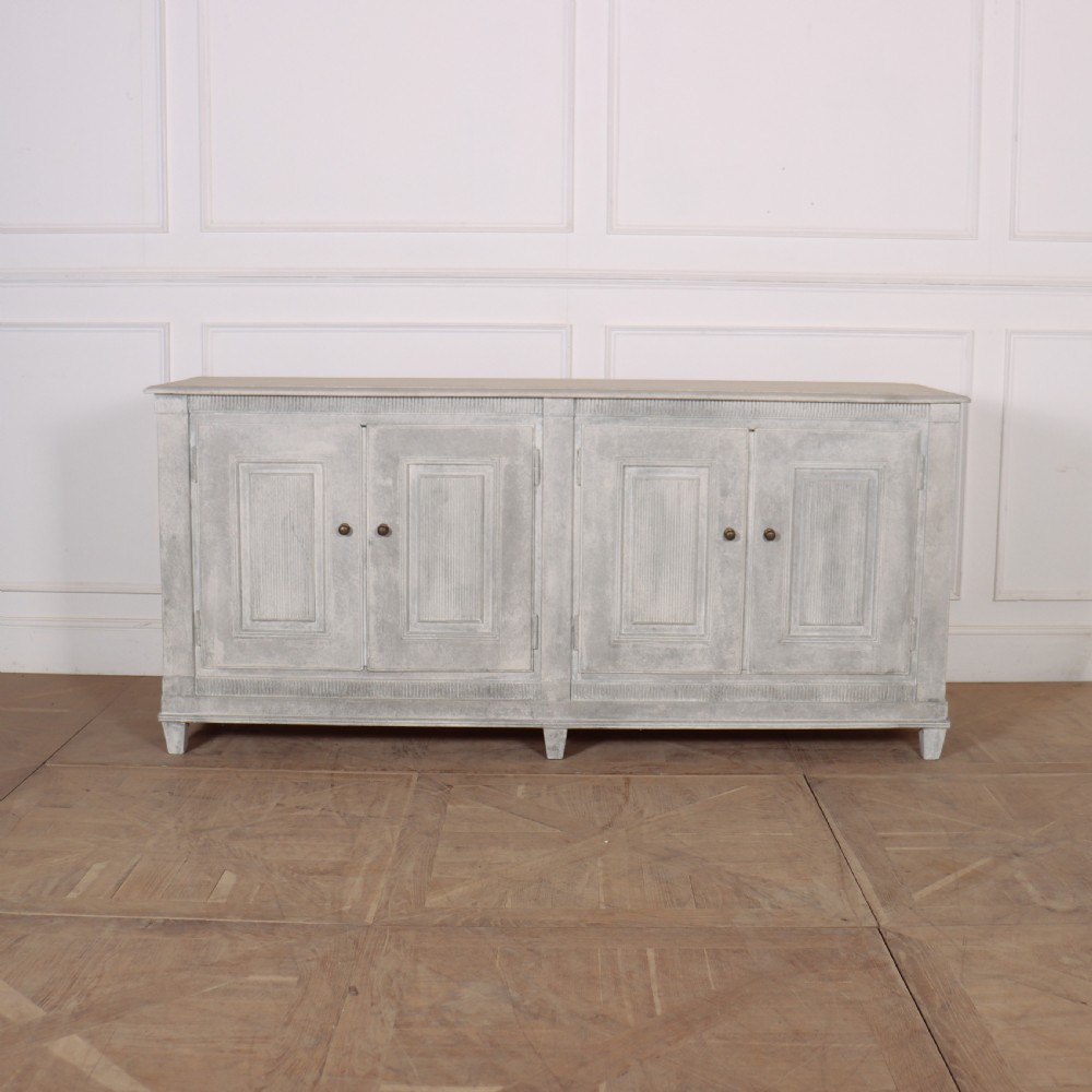 A pair of Swedish enfilades featuring a distressed pale grey painted finish, panelled cupboard doors, small round brass knobs, and short tapered legs. View V
