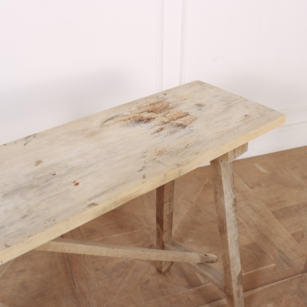 A narrow French bleached oak trestle table featuring a slim rectangular timber top supported by angled trestle legs with diagonal cross bracing. View III