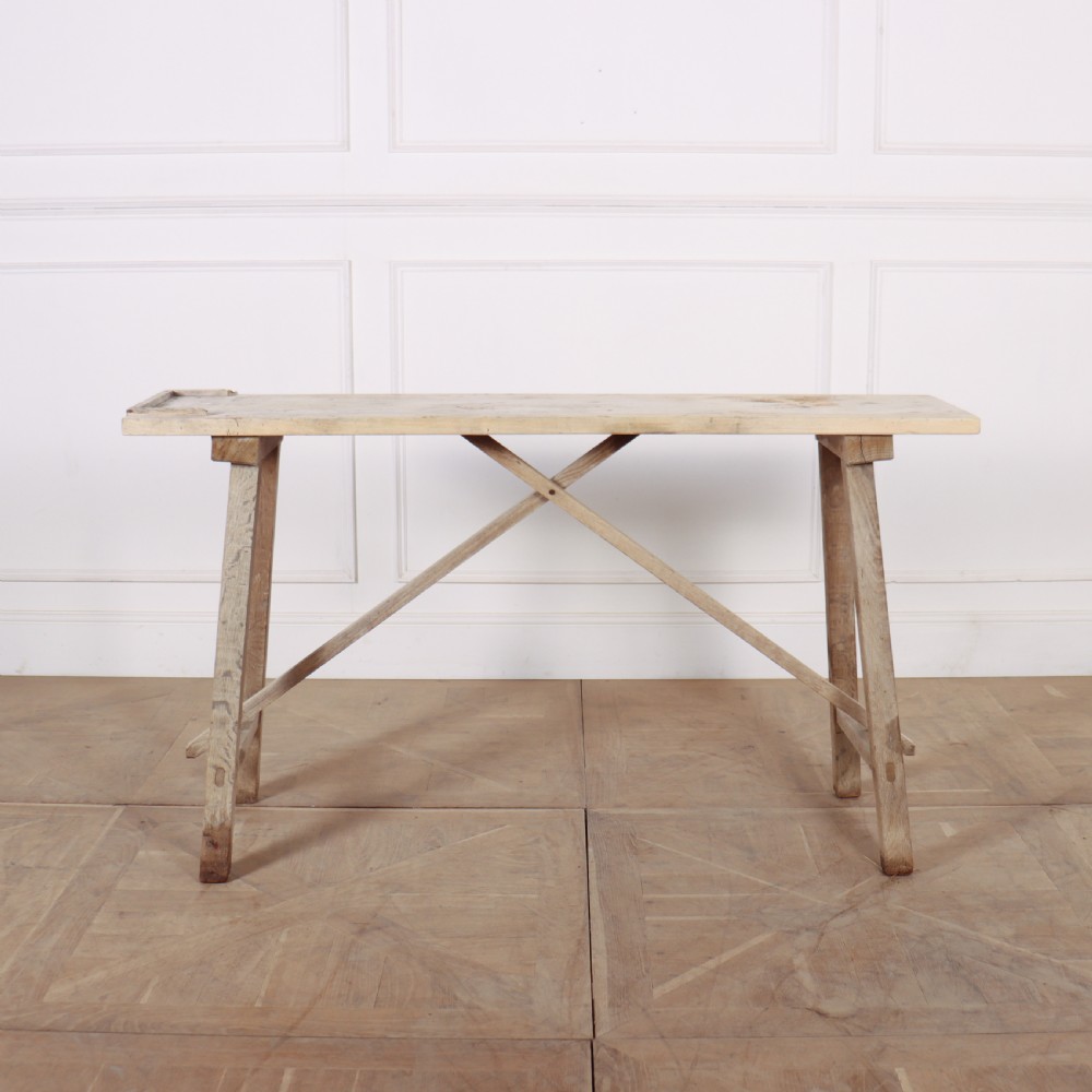A narrow French bleached oak trestle table featuring a slim rectangular timber top supported by angled trestle legs with diagonal cross bracing. View IV