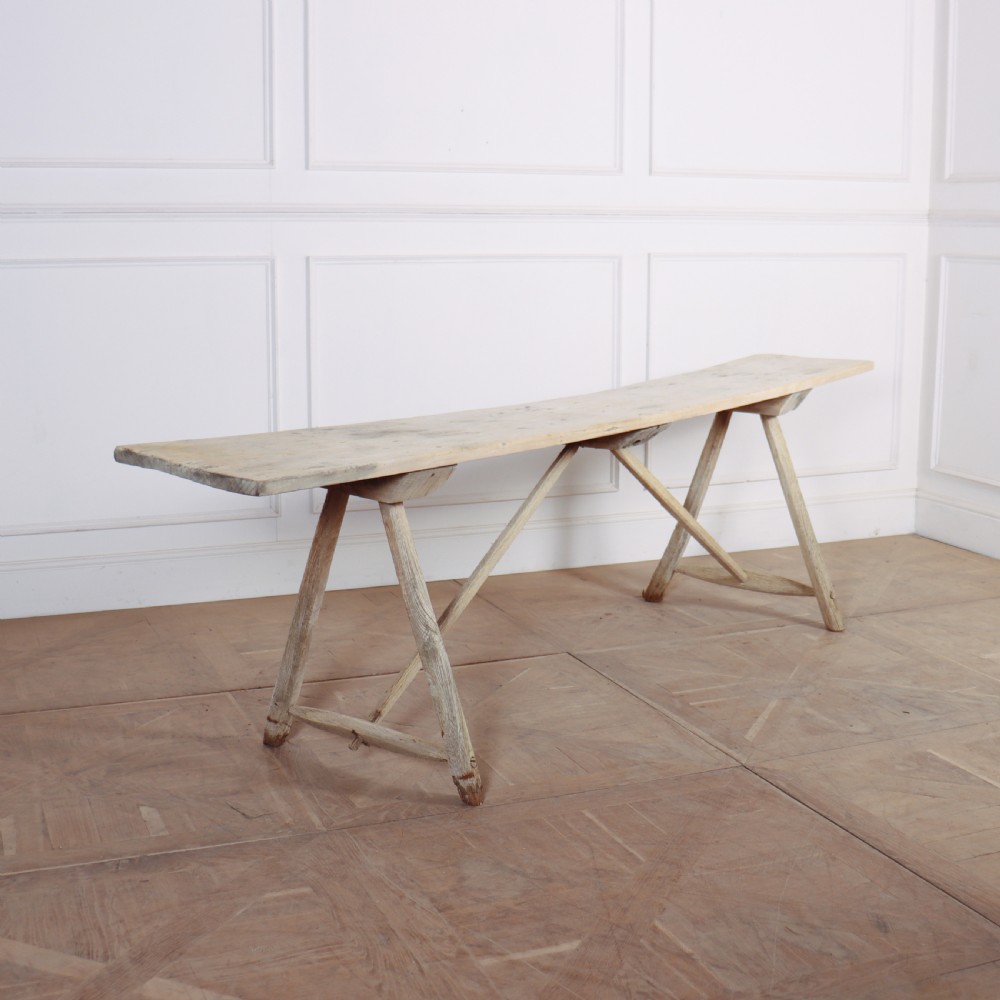 A long, narrow French rustic trestle table constructed from pale oak and poplar timber with A-frame leg supports.