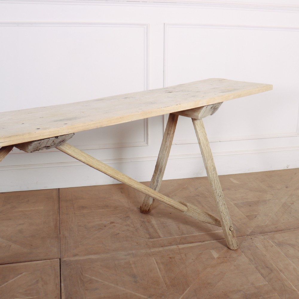 A long, narrow French rustic trestle table constructed from pale oak and poplar timber with A-frame leg supports. View III
