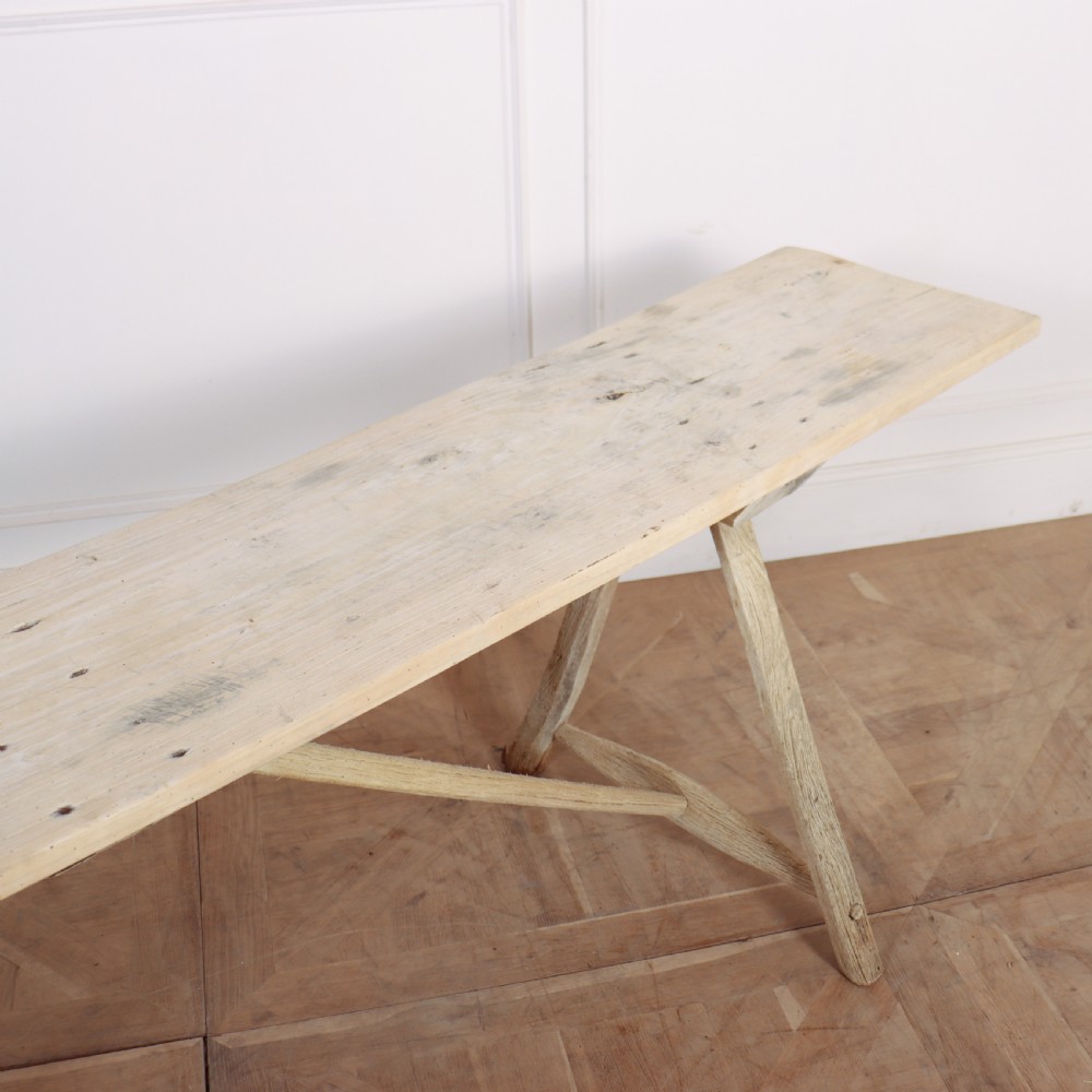 A long, narrow French rustic trestle table constructed from pale oak and poplar timber with A-frame leg supports. View V