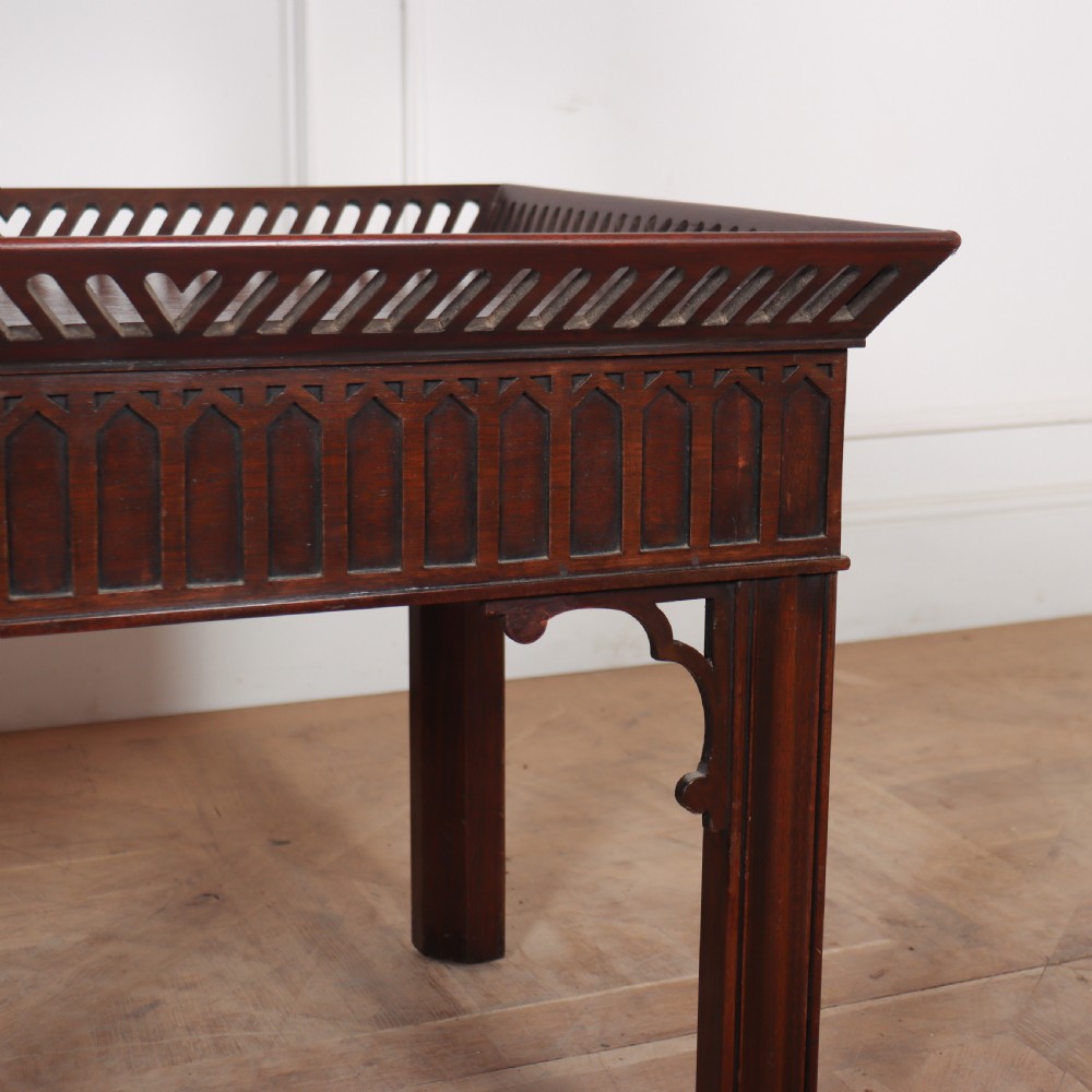 A set of three dark mahogany lamp tables featuring pierced gallery rims and Gothic arch fretwork aprons. View IV