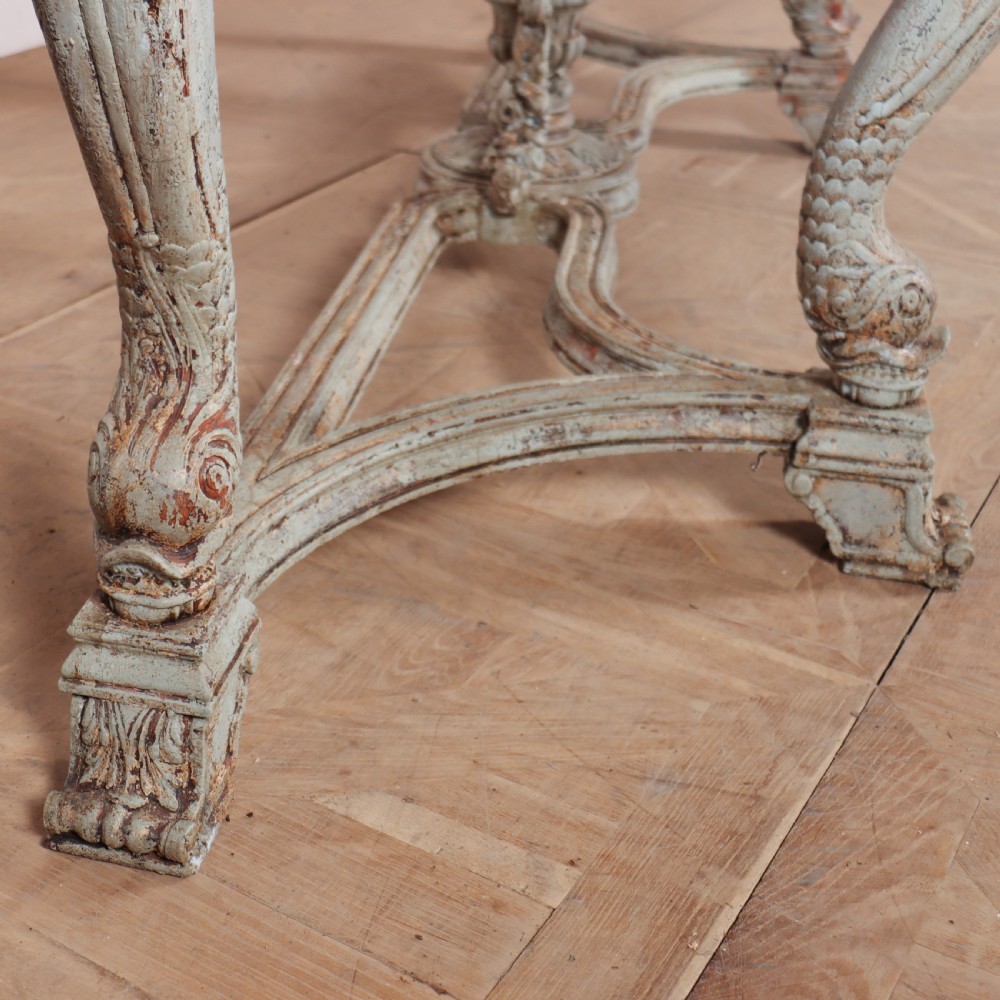 A carved Spanish console table featuring distressed pale blue paintwork, a dark rectangular top, an intricate carved apron, and a central urn finial stretcher. View III