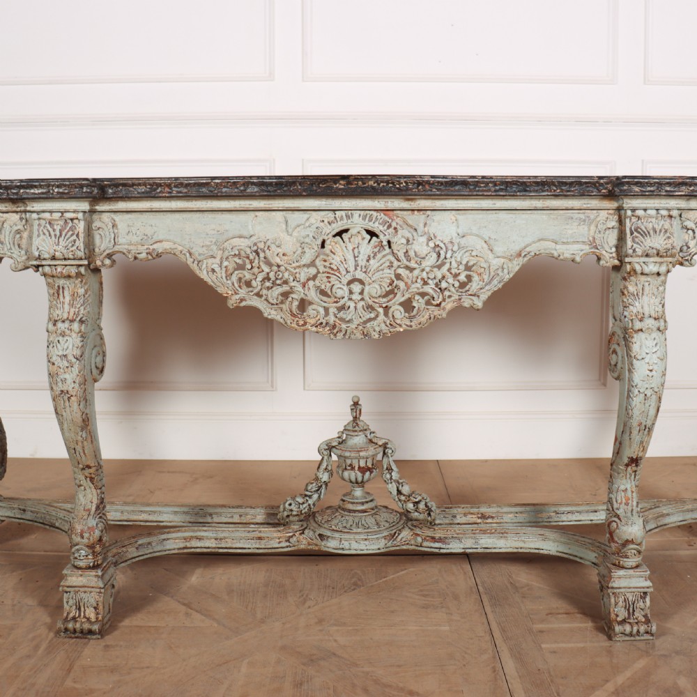 A carved Spanish console table featuring distressed pale blue paintwork, a dark rectangular top, an intricate carved apron, and a central urn finial stretcher. View IV