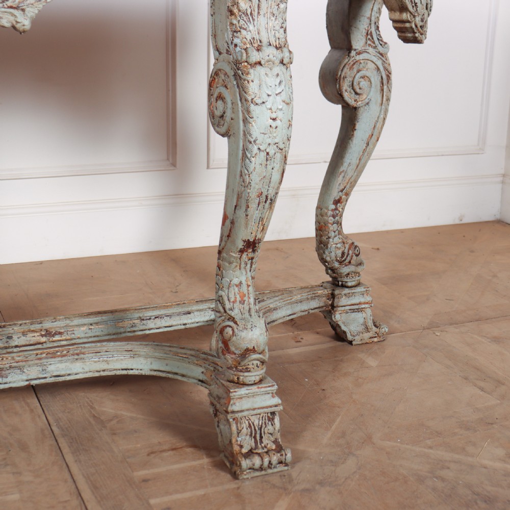A carved Spanish console table featuring distressed pale blue paintwork, a dark rectangular top, an intricate carved apron, and a central urn finial stretcher. View VIII