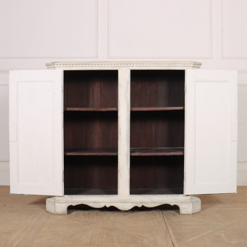 An 18th-century Swedish painted wooden linen cupboard featuring panelled double doors, brass keyhole escutcheons, and a distressed off-white painted finish. View IX
