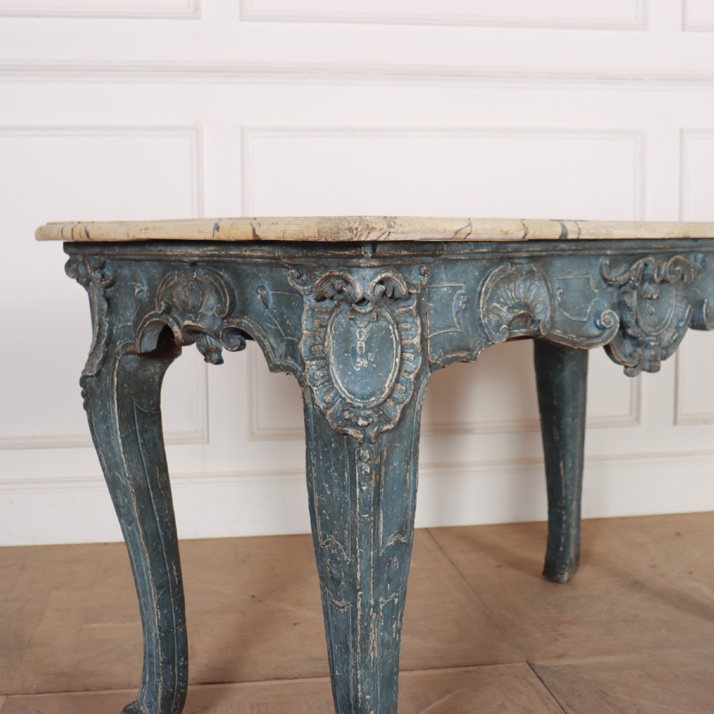 An 18th-century Italian Rococo console table featuring a grey and cream marble top over a distressed blue painted frame with carved scrollwork and cabriole legs. View II