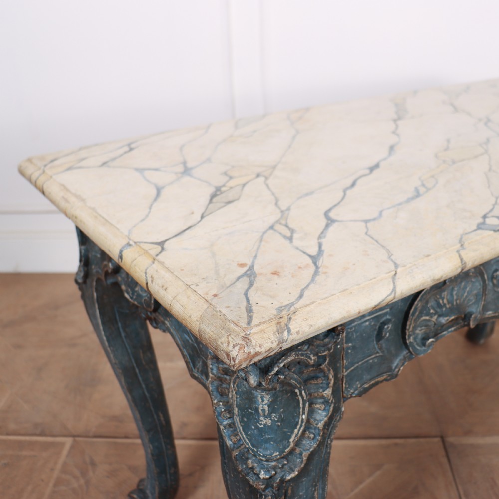 An 18th-century Italian Rococo console table featuring a grey and cream marble top over a distressed blue painted frame with carved scrollwork and cabriole legs. View V