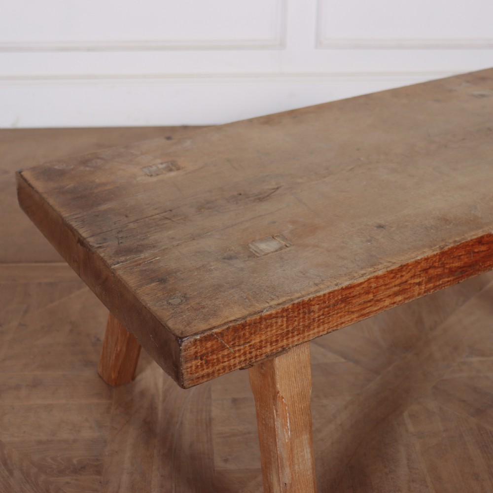 A low French primitive rectangular coffee table made of rustic warm brown timber with splayed tapered legs. View II