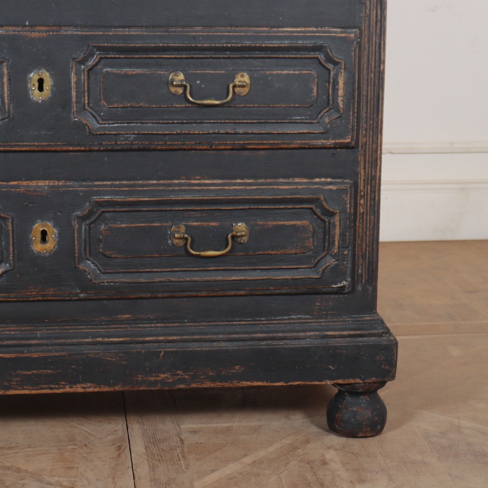 An 18th-century French painted black commode featuring three long drawers with moulded panels, brass drop handles, and a grey marble top. View VII