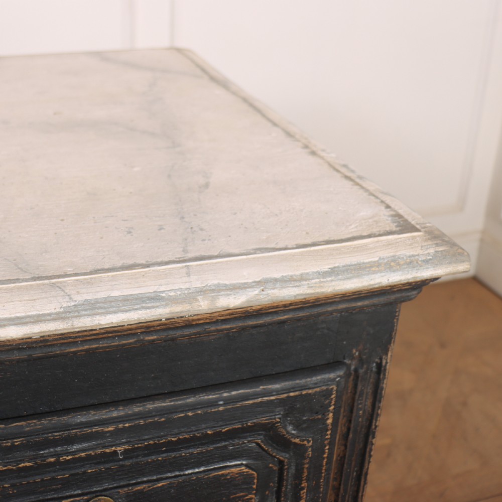 An 18th-century French painted black commode featuring three long drawers with moulded panels, brass drop handles, and a grey marble top. View XII