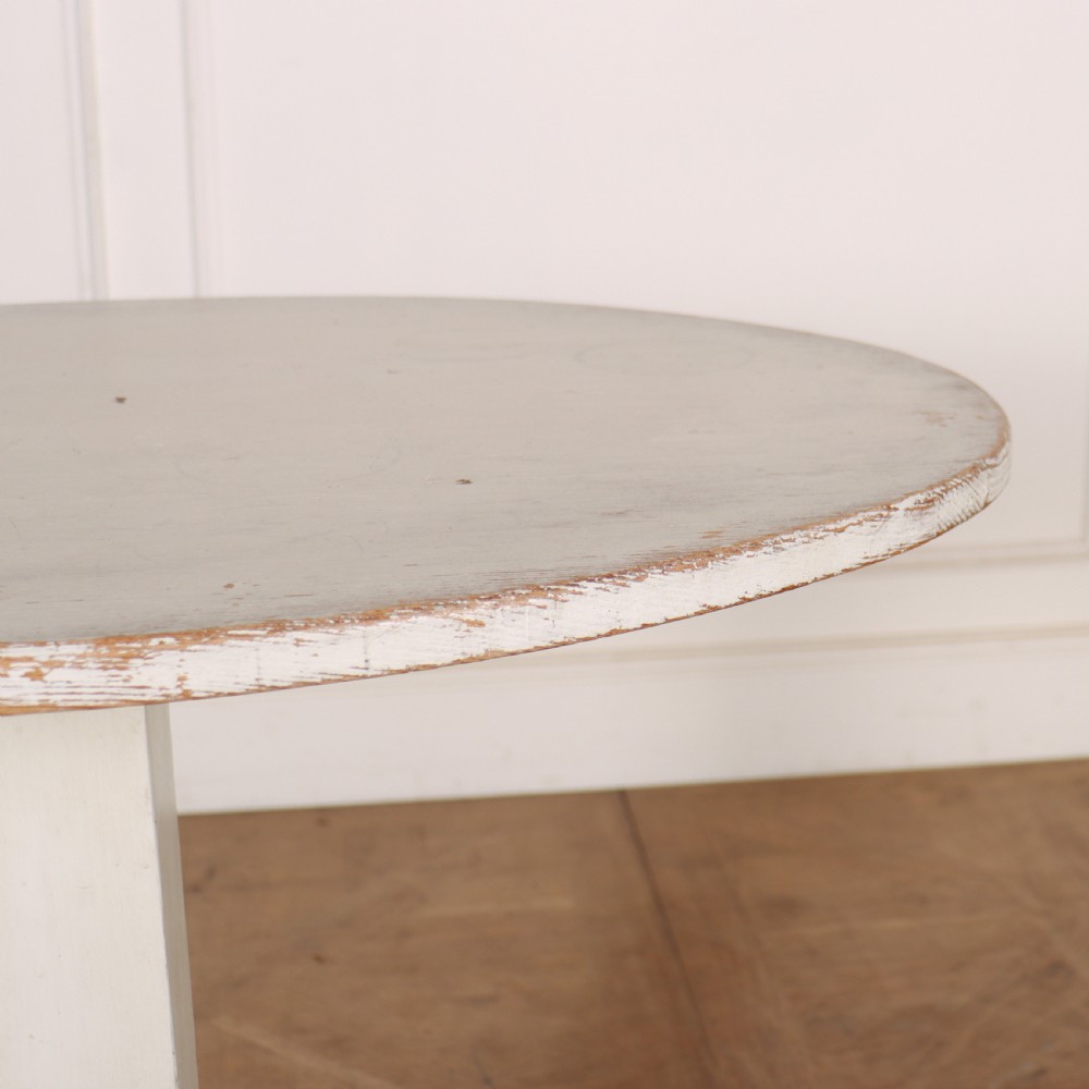 An off-white painted Swedish pedestal table featuring a circular top, a square central column, and a stepped plinth base with visible paint wear along the edges. View II