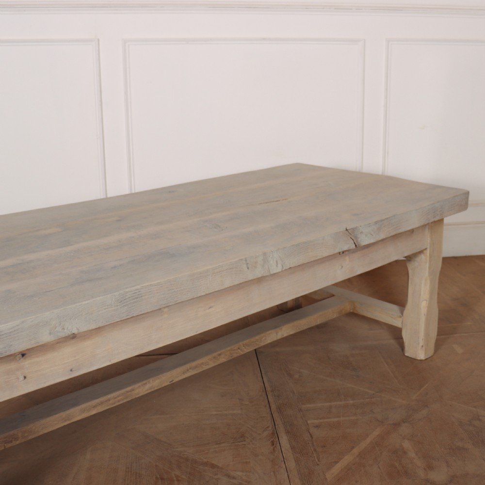 A low rectangular French coffee table constructed from bleached oak, featuring a thick plank top, square legs, a low stretcher, and a small end drawer. View III