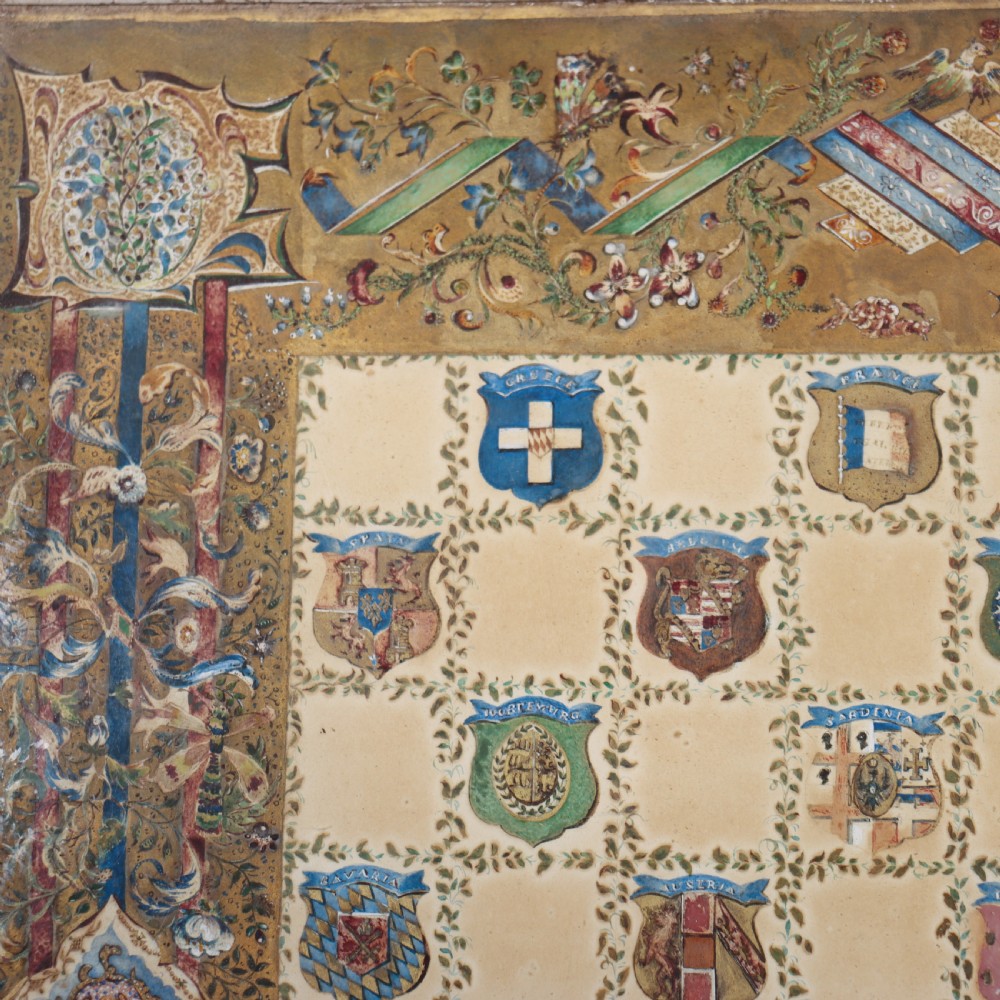 A square painted lamp table featuring a grid of heraldic coats of arms on a cream ground, supported by a carved off-white pedestal base. View V