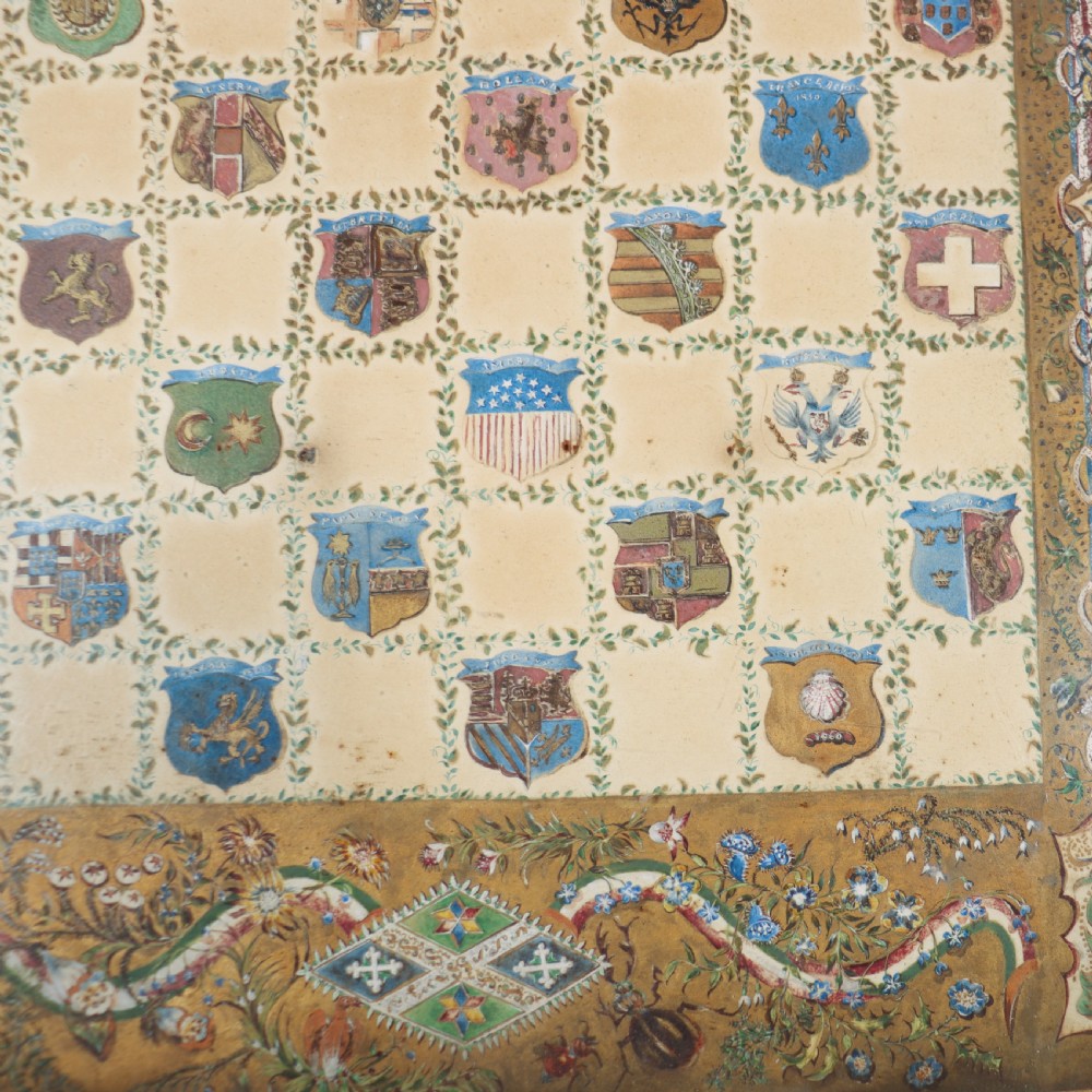 A square painted lamp table featuring a grid of heraldic coats of arms on a cream ground, supported by a carved off-white pedestal base. View VI