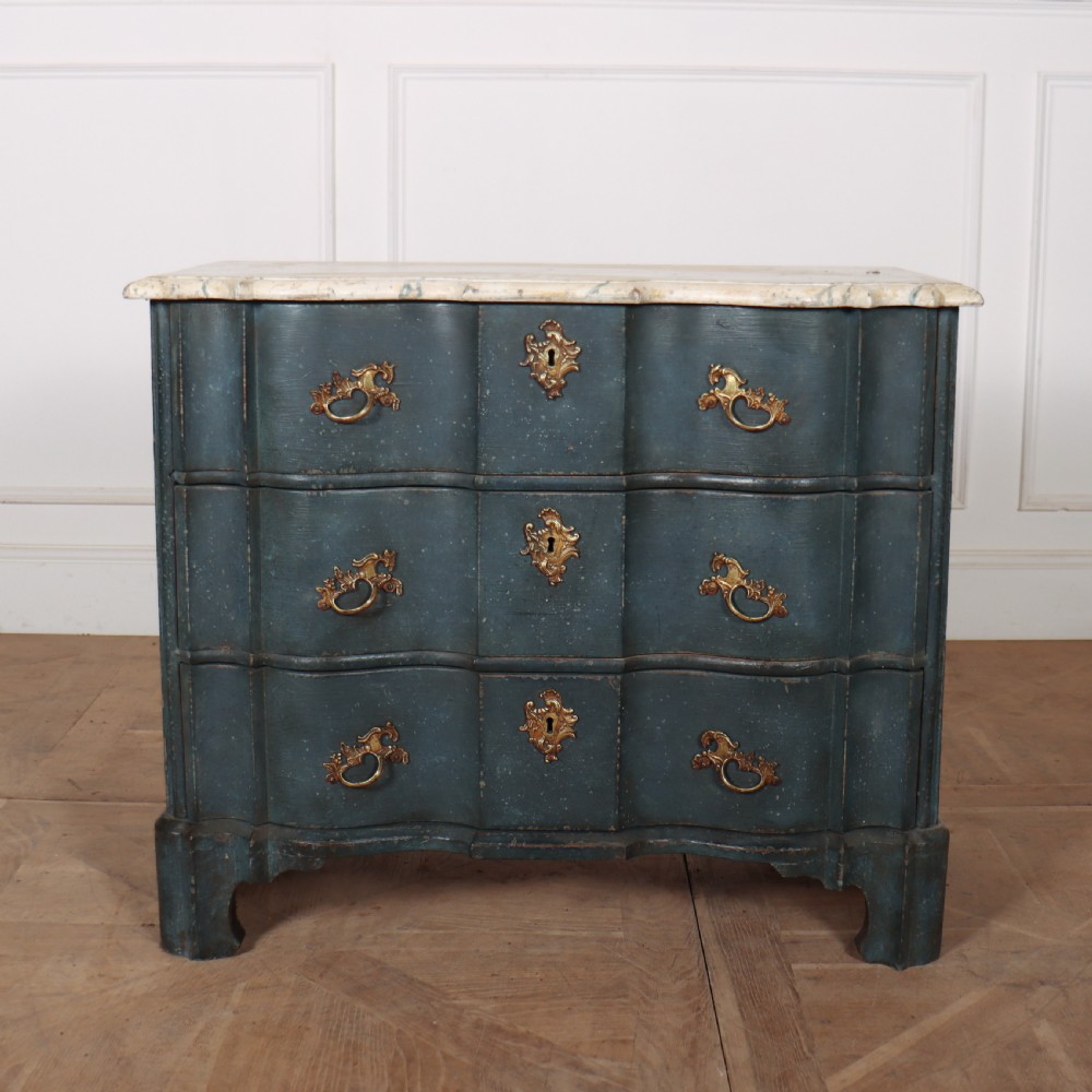 An 18th-century Dutch painted commode featuring a blue serpentine-front wooden body, three drawers with ornamental brass handles, and a contoured white marble top. View II