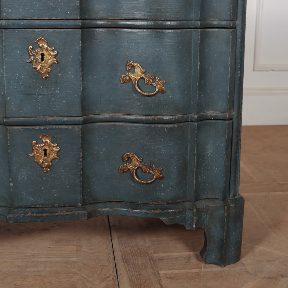 An 18th-century Dutch painted commode featuring a blue serpentine-front wooden body, three drawers with ornamental brass handles, and a contoured white marble top. View VIII