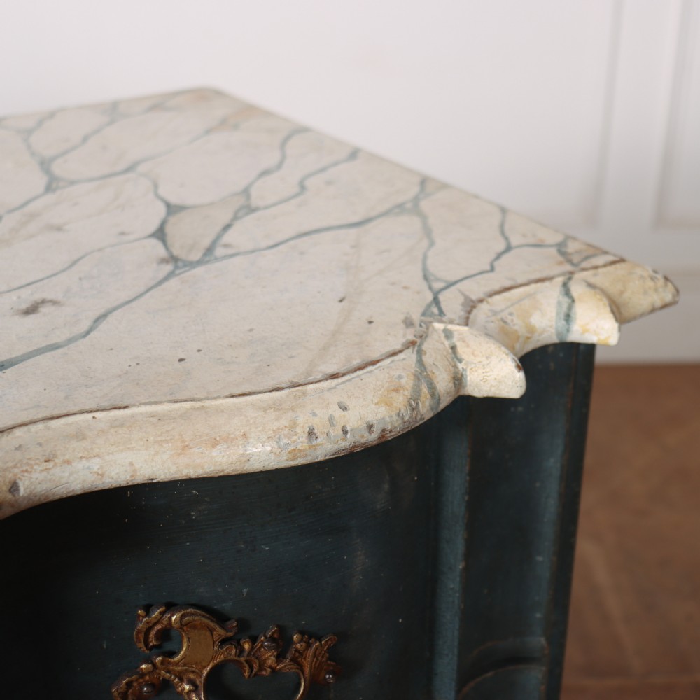 An 18th-century Dutch painted commode featuring a blue serpentine-front wooden body, three drawers with ornamental brass handles, and a contoured white marble top. View XI