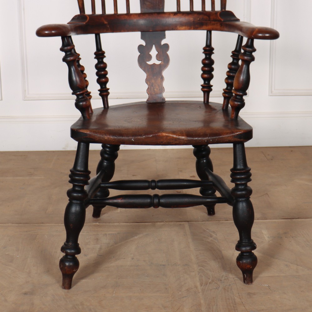 A 19th-century dark brown wood Yorkshire Windsor armchair featuring a hoop back, pierced central splat, turned legs, and curved armrests. View II