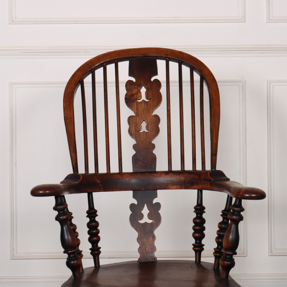 A 19th-century dark brown wood Yorkshire Windsor armchair featuring a hoop back, pierced central splat, turned legs, and curved armrests. View III