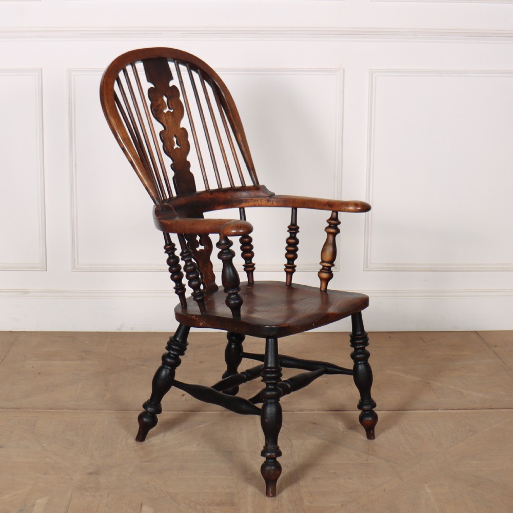A 19th-century dark brown wood Yorkshire Windsor armchair featuring a hoop back, pierced central splat, turned legs, and curved armrests. View IV