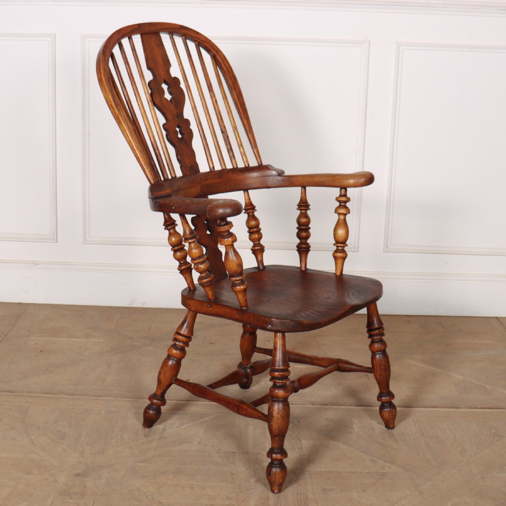 A warm brown wooden Windsor armchair featuring a hoop back, pierced central splat, turned spindles, a contoured seat, and turned legs with stretchers. View II
