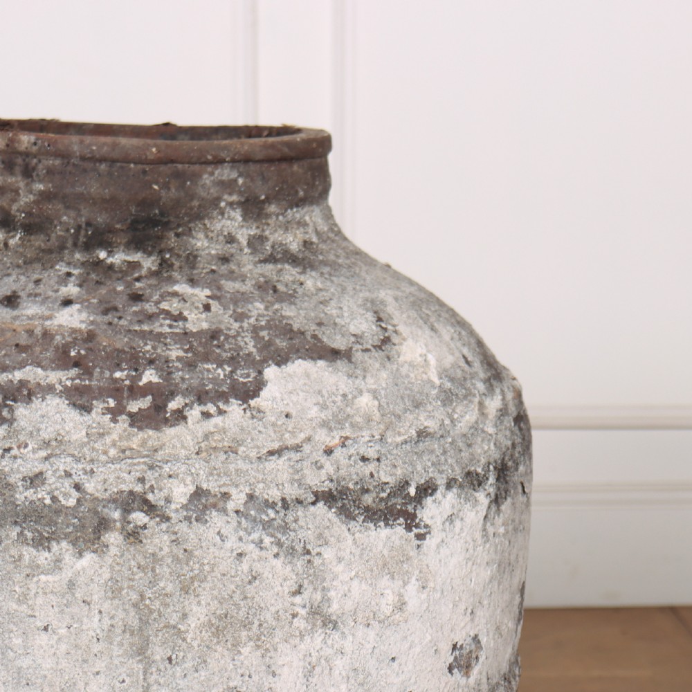 A large, tapered terracotta olive jar featuring a heavily distressed off-white painted surface over dark earthenware clay with a rolled rim. View II