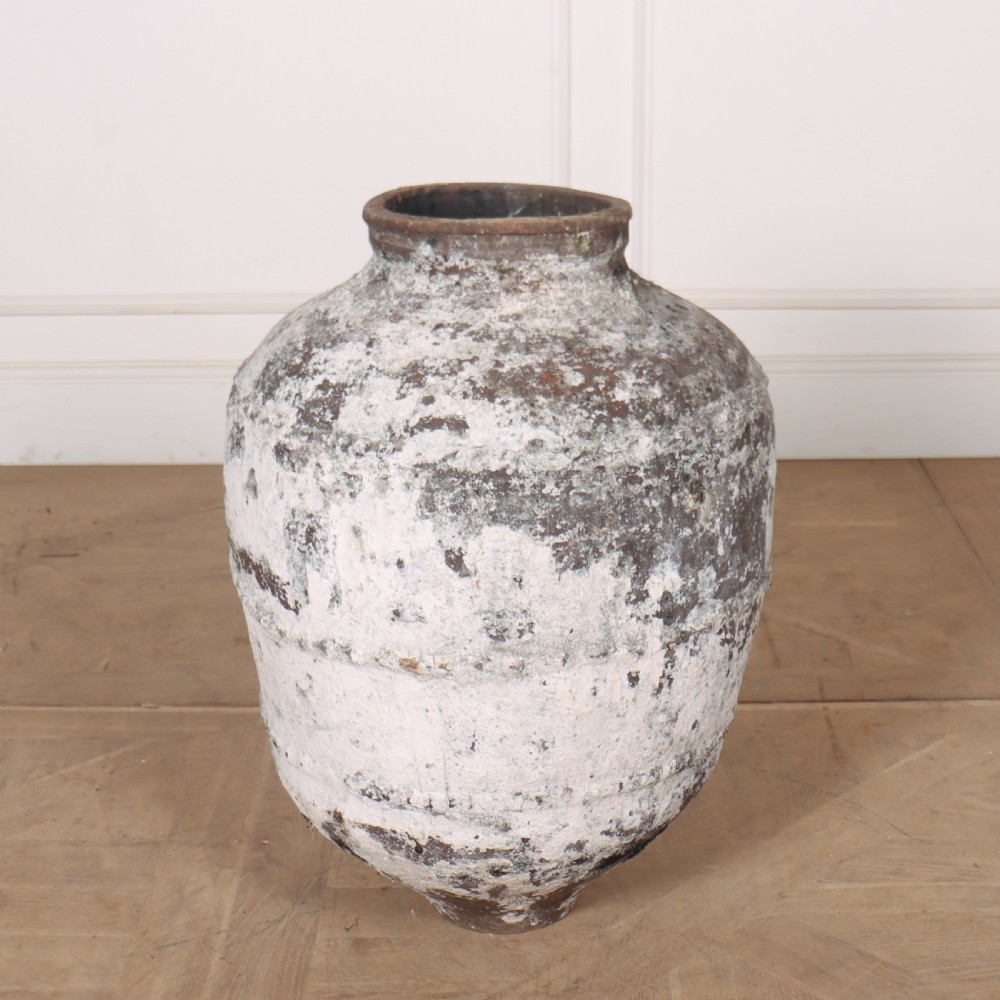 A large, tapered terracotta olive jar featuring a heavily distressed off-white painted surface over dark earthenware clay with a rolled rim. View IV