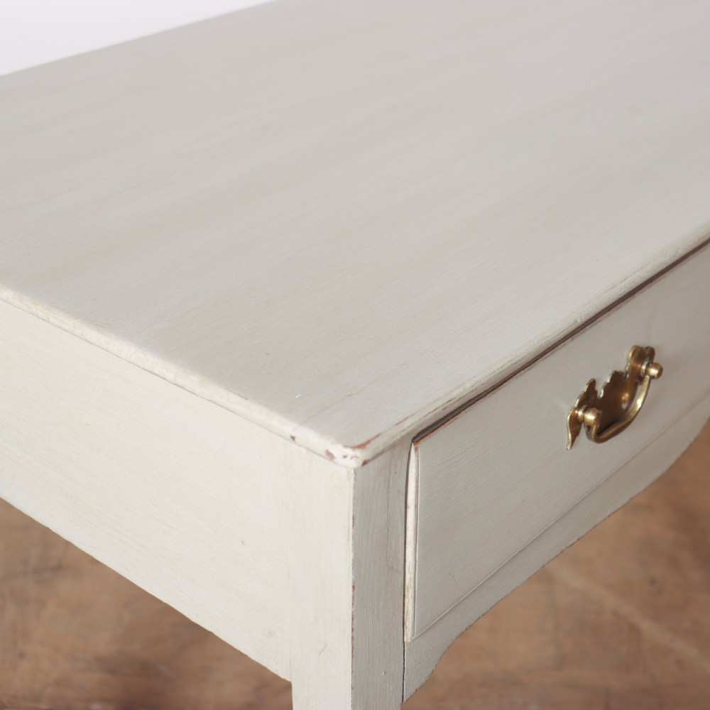 A light grey painted wooden side table featuring two small drawers with brass handles and straight tapered legs against a neutral background. View IV