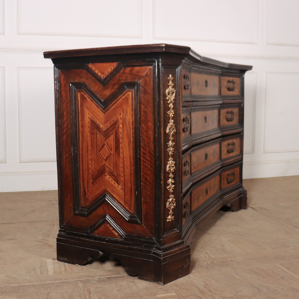 An 18th-century Italian walnut commode featuring four drawers with geometric parquetry inlay and gilt brass pilaster mounts. View VIII