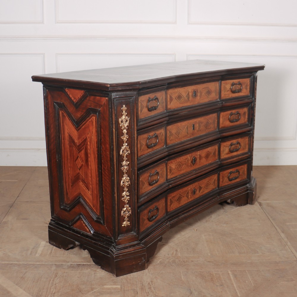 An 18th-century Italian walnut commode featuring four drawers with geometric parquetry inlay and gilt brass pilaster mounts. View IX