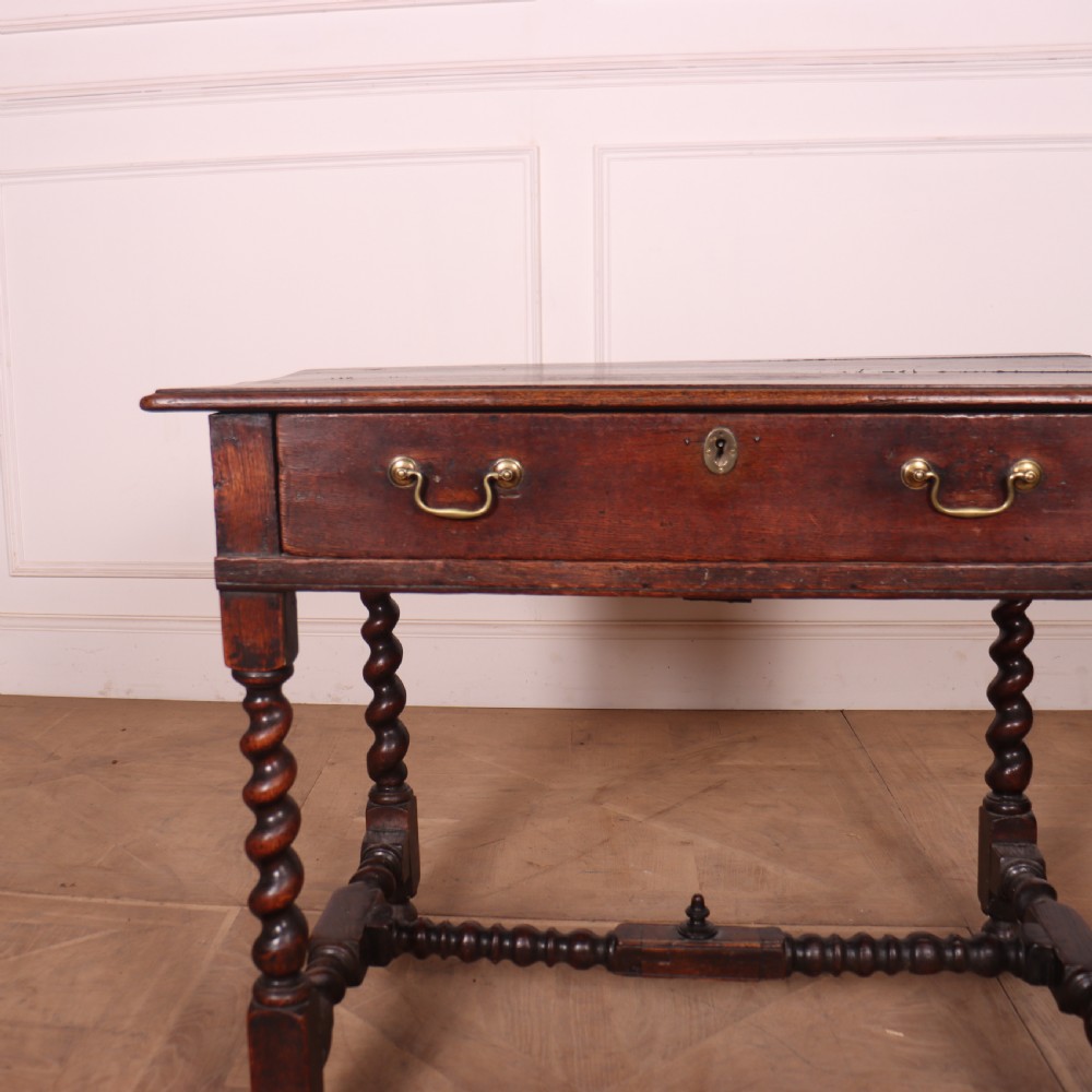 An antique dark oak side table with spiralled barley twist legs, an H-stretcher base, and a single frieze drawer with brass handles. View III
