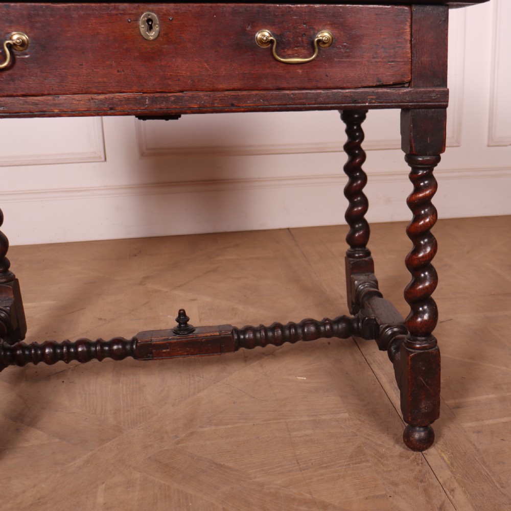 An antique dark oak side table with spiralled barley twist legs, an H-stretcher base, and a single frieze drawer with brass handles. View VII