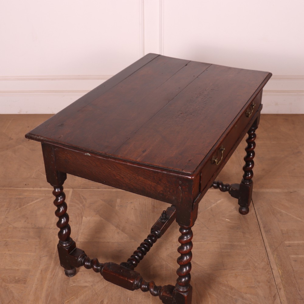 An antique dark oak side table with spiralled barley twist legs, an H-stretcher base, and a single frieze drawer with brass handles. View VIII