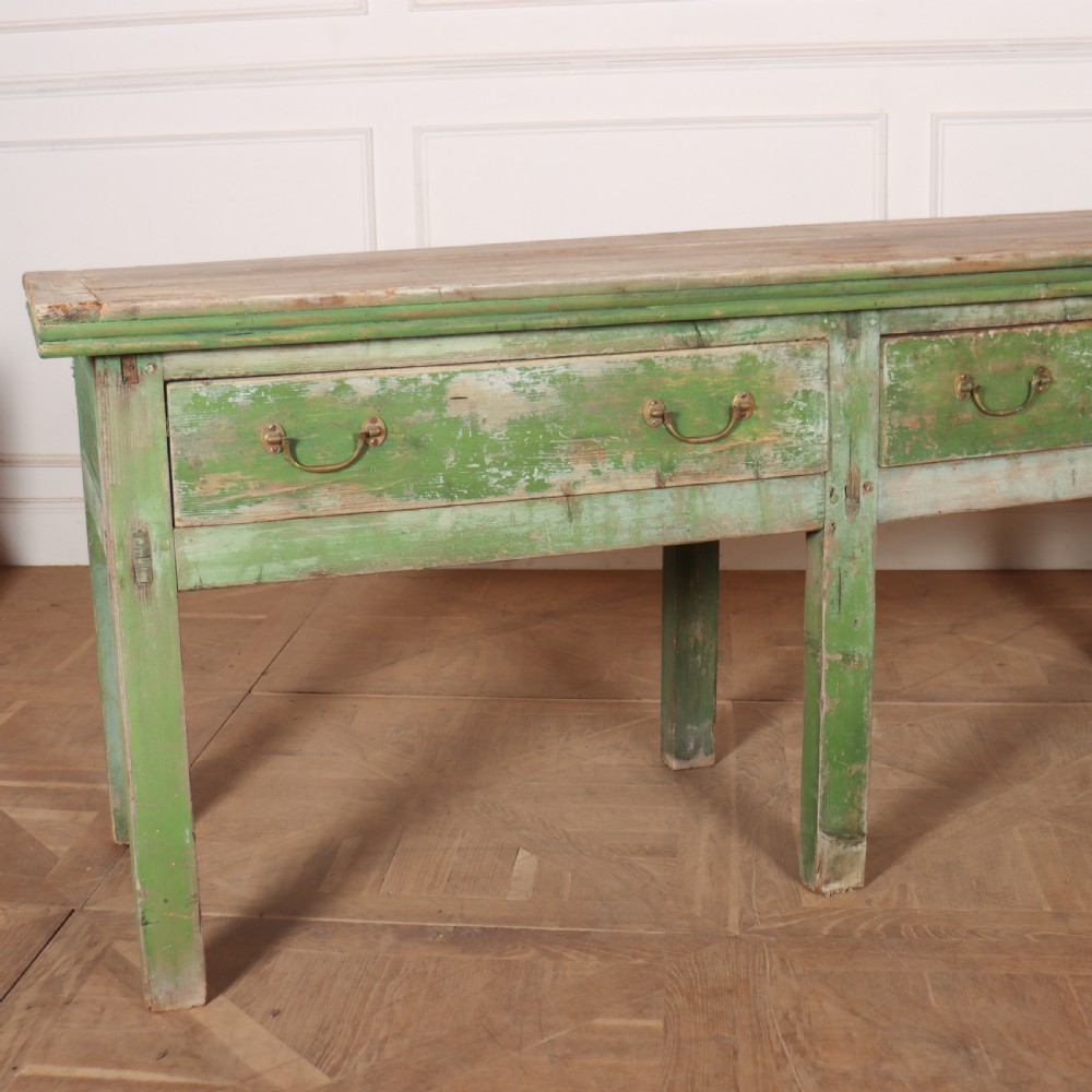 An exceptionally long antique English pine dresser base featuring a distressed green painted finish, four drawers with drop handles, and an unpainted timber top surface. View II