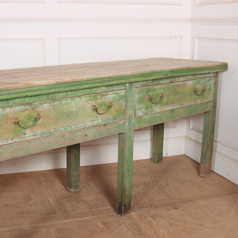 An exceptionally long antique English pine dresser base featuring a distressed green painted finish, four drawers with drop handles, and an unpainted timber top surface. View IV