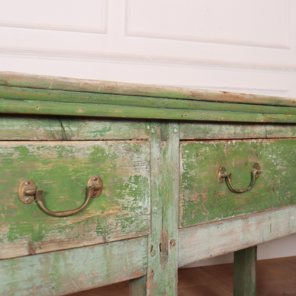 An exceptionally long antique English pine dresser base featuring a distressed green painted finish, four drawers with drop handles, and an unpainted timber top surface. View VI