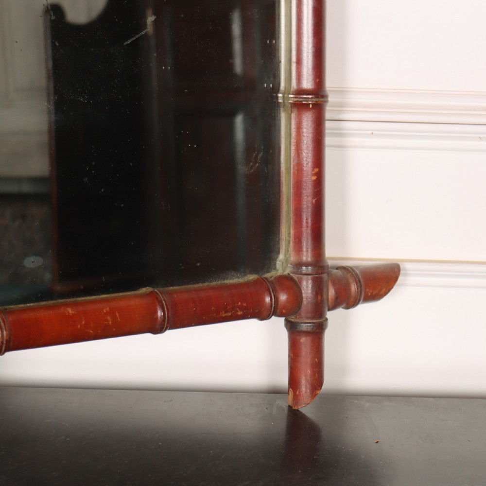A rectangular French wall mirror featuring a carved wooden frame crafted to imitate bamboo with crossed, protruding corner joints. View IV