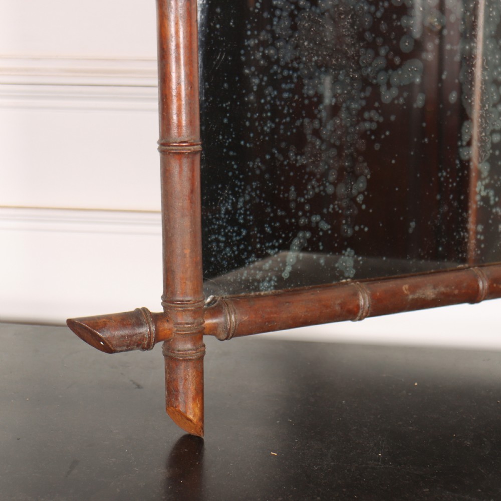 A rectangular antique French wall mirror featuring a carved wooden frame styled to resemble bamboo stems with protruding corner joints and distressed glass. View IV