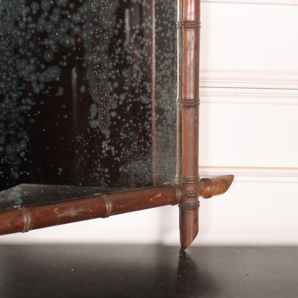 A rectangular antique French wall mirror featuring a carved wooden frame styled to resemble bamboo stems with protruding corner joints and distressed glass. View V