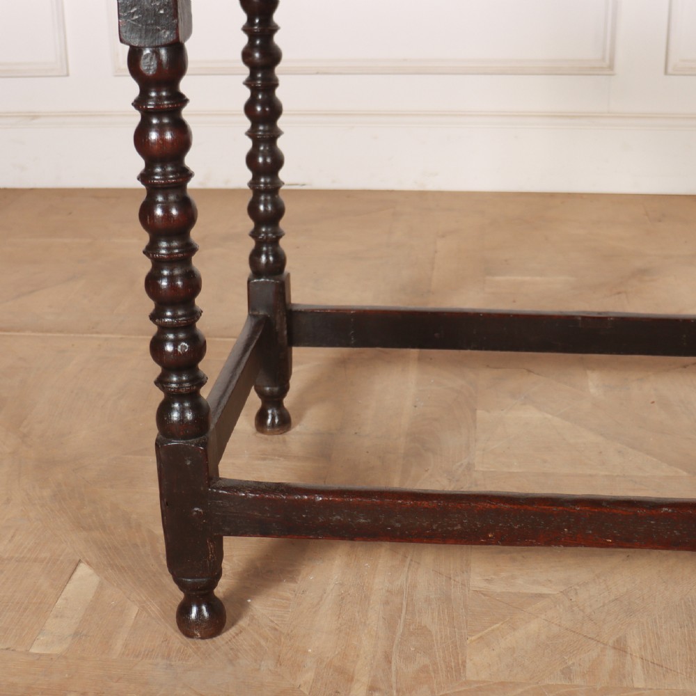 An 18th-century dark oak side table featuring a rectangular top, single drawer with brass handles, bobbin turned legs, and a box stretcher base. View II